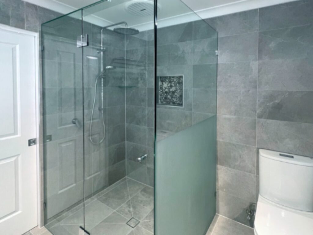 Clear glass enclosure with a frosted half panel designed as shower screens for small bathrooms.